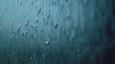 Modern duvardan akan suyun yavaş akışı, parlak koyu mermer yüzeyde akan akarsular, soyut arkaplan minimalist tasarımı. Yüksek kalite 4k görüntü