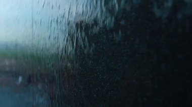 Modern duvardan akan suyun yavaş akışı, parlak koyu mermer yüzeyde akan akarsular, soyut arkaplan minimalist tasarımı. Yüksek kalite 4k görüntü