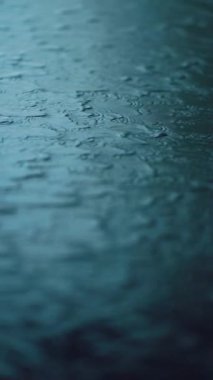 Modern duvardan akan suyun yavaş akışı, parlak koyu mermer yüzeyde akan akarsular, soyut arkaplan minimalist tasarımı. Yüksek kalite 4k görüntü, dikey video