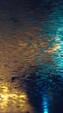 Modern duvardan akan suyun yavaş akışı, parlak koyu mermer yüzeyde akan akarsular, soyut arkaplan minimalist tasarımı. Yüksek kalite 4k görüntü, dikey video