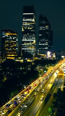 Büyük şehirde yoğun saatler, arabalar ve trafik, modern gökdelenler gökdelenler gökdelen ve aydınlatılmış cadde, finans merkezi bölgesi, Bangkok Tayland, hipervane ya da zamanaşımı dikey video, 4k görüntü