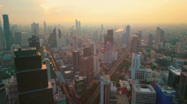 Bangkok 'un modern gökdelenlerinin insansız hava aracı görüntüsü, güneşli günbatımında finans merkezi manzarası, Tayland' ın gelecekteki başkenti. Yüksek kalite 4k görüntü