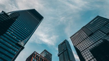 Yüksek gökdelenler, perspektiften bakan binalar, şehir merkezindeki modern çelik ve camdan mimari, büyük şehrin ufuk çizgisi, düşük açılı bakış açısı. Yüksek kalite fotoğraf