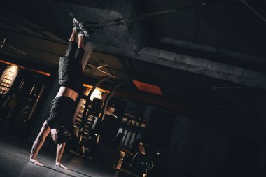 Vücut geliştiren bir erkek spor salonunda çekirdek kuvveti için TRX amuda kalkıyor antreman sırasında TRX amuda kalkarken süspansiyon eğitimi alıyor. Yüksek kalite fotoğraf