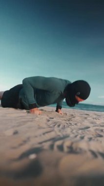 Erkek vücut geliştirici, gün batımında kumsalda şınav çekiyor erkek sporcu, gün batımında kumlu sahilde şınav çekiyor. Yüksek kalite 4k görüntü