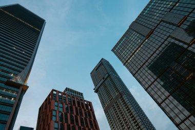 Yüksek gökdelenler, perspektiften bakan binalar, şehir merkezindeki modern çelik ve camdan mimari, büyük şehrin ufuk çizgisi, düşük açılı bakış açısı. Yüksek kalite fotoğraf