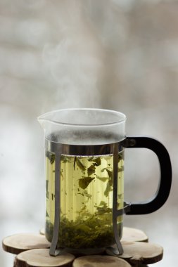 Pencerenin önünde sıcak yeşil çay ile Frenchpress