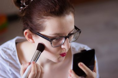 Çekici kadın aynaya bakarken makyaj uygulamak