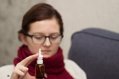 Bir eşarp ile sprey burun için hasta kadın