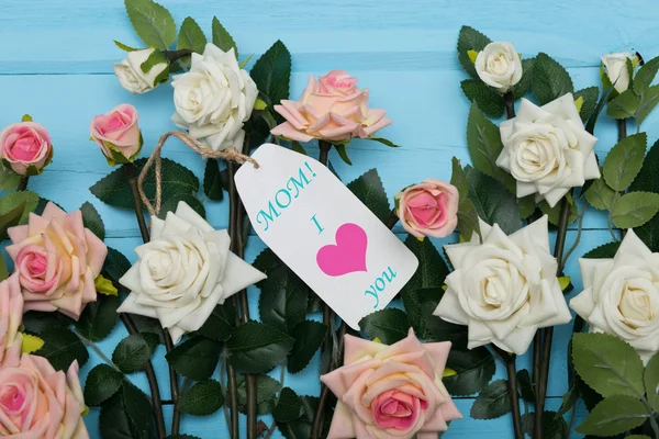 Scheda giorno madri e belle rose su sfondo blu in legno — Foto Stock