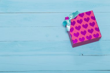 Hediye kutusu kalpleri ile pembe ve mavi arka plan üzerinde yay