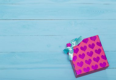 Hediye kutusu kalpleri ile pembe ve mavi arka plan üzerinde yay