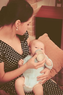 evde anne bebek bir süt şişesiyle beslenme.