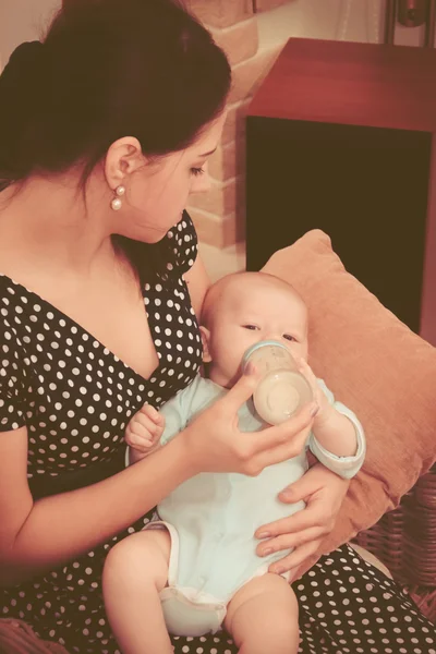 evde anne bebek bir süt şişesiyle beslenme.