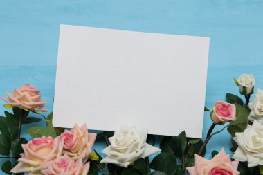 çiçekli bir ahşap mavi zemin üzerine beyaz boş kartı