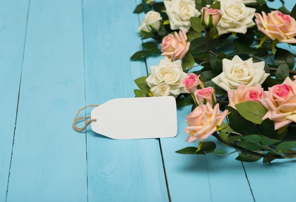 Bianco carta bianca con fiori su uno sfondo blu di legno — Foto Stock