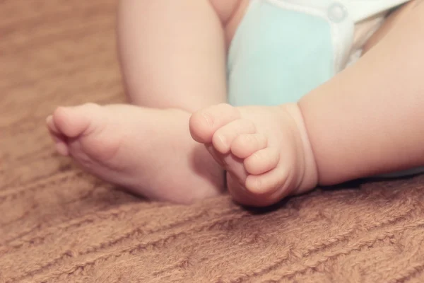 Piedini neonato su sfondo lavorato a maglia, concetto di festa della mamma — Foto Stock