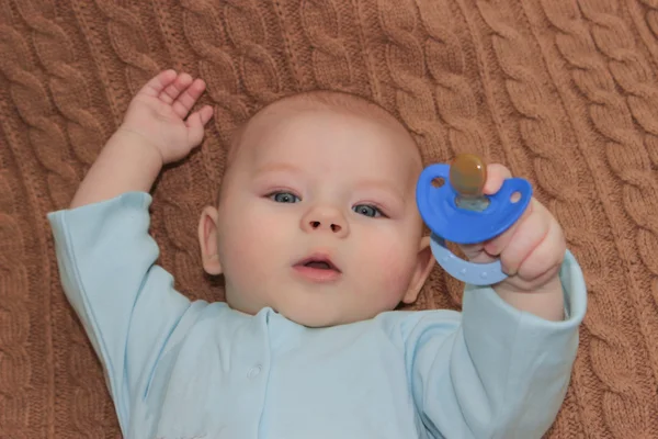 Bambino ragazzo in possesso di un capezzolo blu — Foto Stock