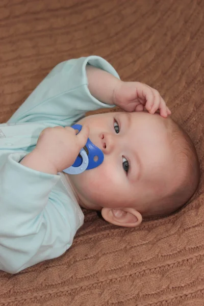 Bambino ragazzo in possesso di un capezzolo blu — Foto Stock