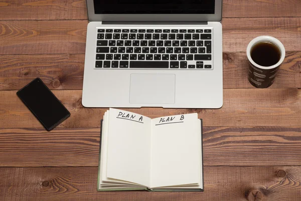 İş planı, telefon, laptop ile defter. Kahve Tablo