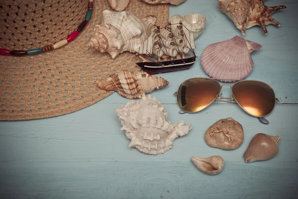 Sommerhut, Muscheln, Sonnenbrille und Schiff auf blauem Hintergrund — Stockfoto