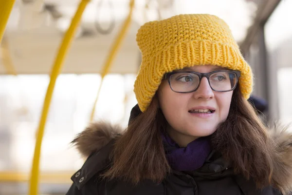 Toplu taşıma sürme sarı şapkalı genç kadın