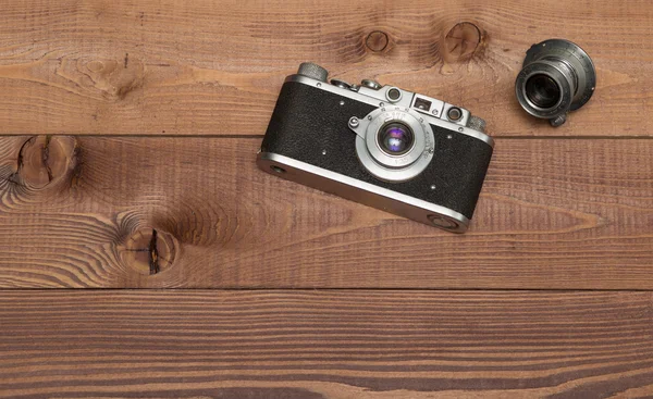 Cámara vintage con lente en el fondo de madera —  Fotos de Stock