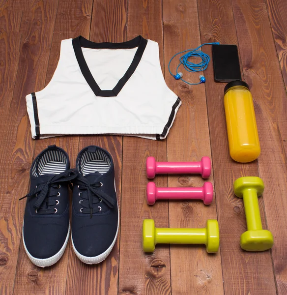 Sport tilbehør: tøj, sko, vægte, flaske, telefon på træ baggrund - Stock-foto
