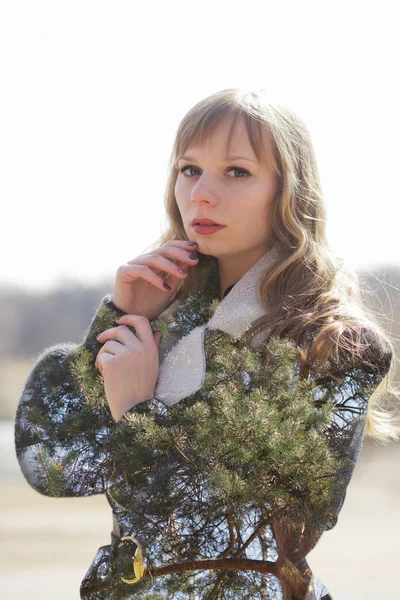 Attraente giovane donna in cappotto con doppia esposizione effetto pini — Foto Stock