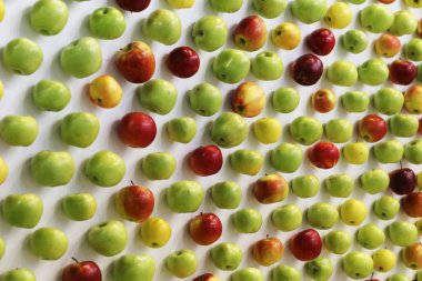 Beyaz masa üzerinde kırmızı, yeşil ve sarı elmalar