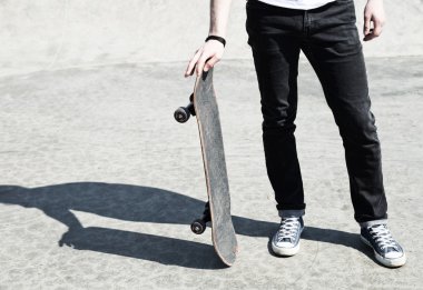 Young man holding his skate board