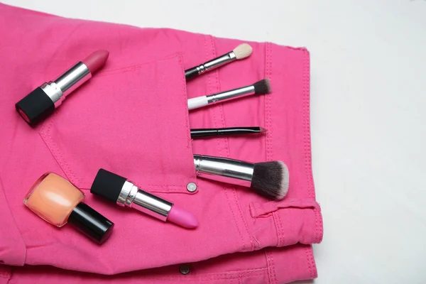 Frau Make-up Accessoires in rosa Jeans. flache Lagesicht. — Stockfoto