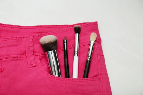 Frau Make-up Accessoires in rosa Jeans. flache Lagesicht. — Stockfoto