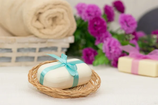 Big piece of beige soap in busket, witn blue  bow, flowers and t — Stock Photo, Image