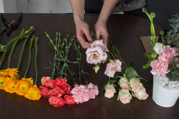 Florista fazendo buquê laranja e rosa brilhante — Fotografia de Stock