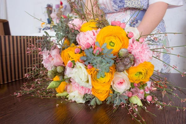 Fiorista rendendo brillante bouquet arancione e rosa — Foto Stock