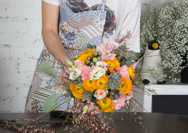 Fiorista rendendo brillante bouquet arancione e rosa — Foto Stock