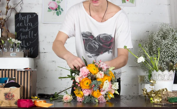 Florista fazendo buquê laranja e rosa brilhante — Fotografia de Stock