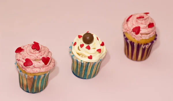 Cupcakes crema del desierto rosa y blanco sobre fondo rosa — Foto de Stock