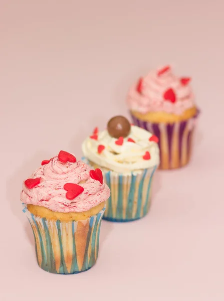 Cupcakes crema del desierto rosa y blanco sobre fondo rosa — Foto de Stock