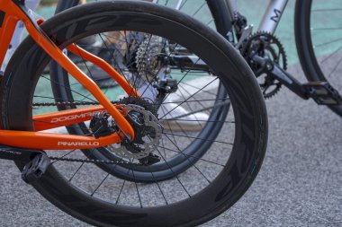 Modern yol bisikleti tekerleklerine, disk frenlerine ve bisiklet yoluna yakın çekim. Performans motosikletleri ve spor hareketlilik konseptiyle ayrıntılı bisiklet ekipmanı sahnesi.