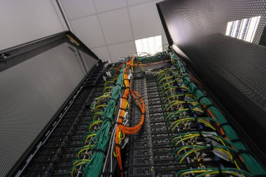 Modern veri merkezi altyapı ortamında ağ kablolarına ve bağlı donanıma sahip sunucu rafı.