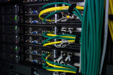 Modern veri merkezi altyapı ortamında ağ kablolarına ve bağlı donanıma sahip sunucu rafı.