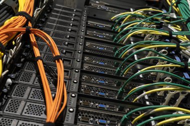 Modern veri merkezi altyapı ortamında ağ kablolarına ve bağlı donanıma sahip sunucu rafı.