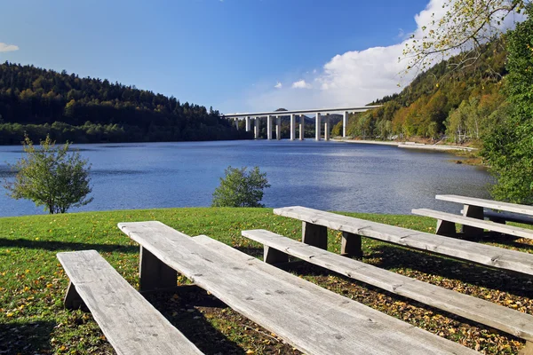Bankların üzerinde bir göl manzaralı bir Karayolu Köprüsü