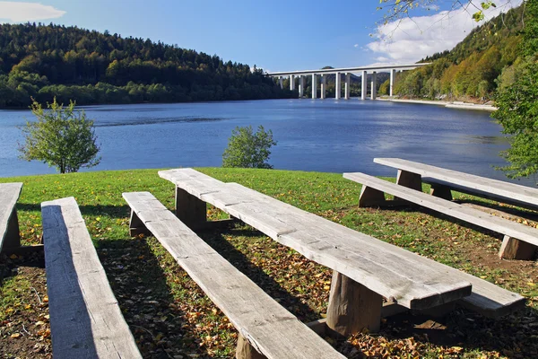 Bankların üzerinde bir göl manzaralı bir Karayolu Köprüsü 