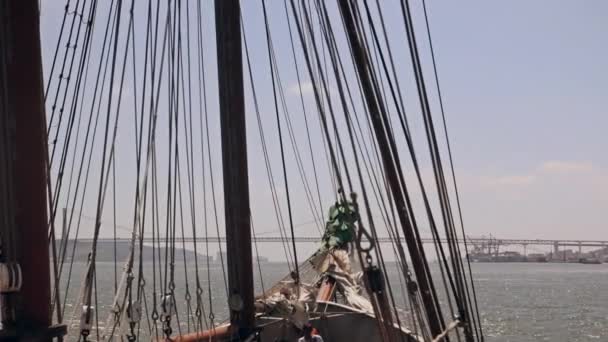 Fartyget seglar genom vågorna på en bro bakgrund Lissabon — Stockvideo