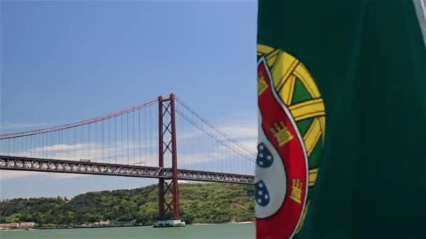 Bandera portuguesa en un barco sobre el fondo del puente del 25 de abril y la estatua de Jesús — Vídeos de Stock