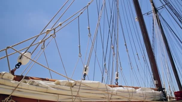 Voile pliée et gréement d'un voilier contre le ciel 