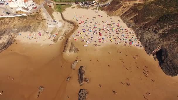 La gente si rilassa sulla spiaggia Zambujeira de Mar vicino alle rocce vista aerea — Video Stock